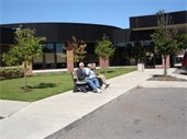 A family sitting on a bench outside of the Civic Park Senior Center