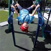 A child hanging upside down on a playground