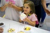 A young girl smiling with a bowl of ice cream