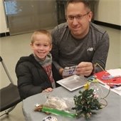 A parent and child in front of a craft table