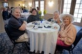 A group smiling at a dinner table with historical items