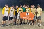 A softball team holding a champion banner