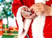 A man dressed like santa dialing on a cell phone