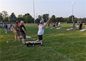 A man tossing a beanbag while playing cornhole