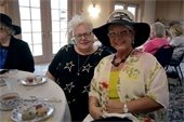 Two woman sitting in a vintage home and smiling