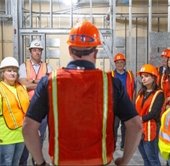 Ted Davis in the foreground facing a group. He's wearing protective equipment