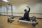 An instructor stretching on a Pilates machine